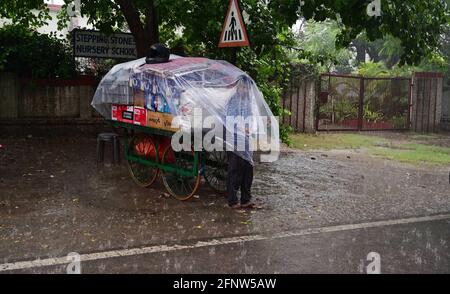 Prayagraj, Uttar Pradesh, Indien. Mai 2021. Prayagraj: Ein Straßenverkäufer muffelt am Mittwoch, den 19. Mai 2021, Plastikfolie gegen Regenschauer in Prayagraj aus. Quelle: Prabhat Kumar Verma/ZUMA Wire/Alamy Live News Stockfoto