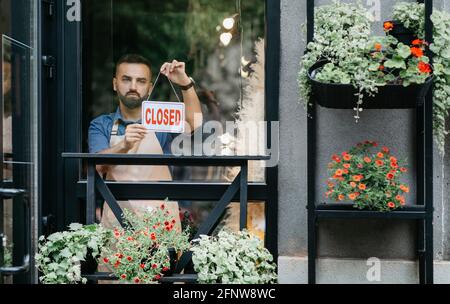 Kleines Unternehmen, Eigentümer des Blumenstudios schließt Geschäft am Ende des Tages und Covid-19-Sperre Stockfoto