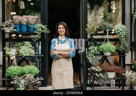 Moderner Blumenladen im rustikalen Stil und positiver Verkäufer Stockfoto