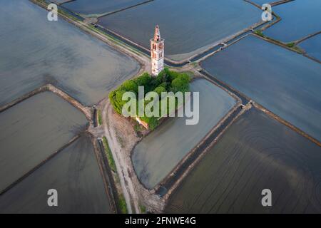 Sonnenuntergang über den Reisfeldern und verlassene Kirche von Sant'Antonio. Casaleggio di Novara, Novara, Piemont, Italien. Stockfoto