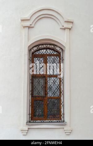 Ein Fenster mit einem schönen Grill in der alten orthodoxen Kirche. Außenansicht der Fassade des Gebäudes. Stockfoto