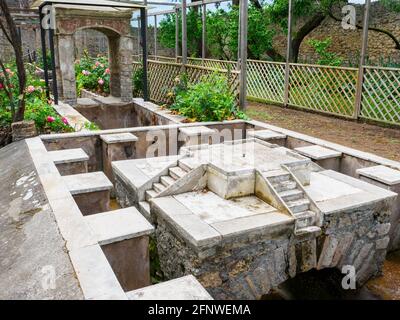 Monumentaler Brunnen gefolgt von einem kleinen Tempel und einem Teich im Garten Wasserkanal Haus des Octavius Quartio - Pompeji archäologische Stätte, Italien Stockfoto