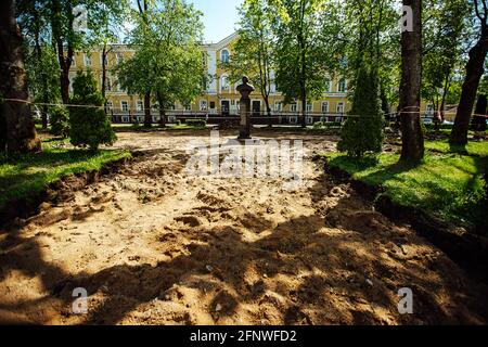 Ein Warnband verbietet den Durchgang. Absperrband um den gefährlichen Ort. Reparaturarbeiten an der Stelle des Asphaltausfalls nach der Katastrophe. Absperrband Stockfoto