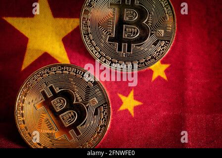 Bitcoin-Münzen auf der Flagge Chinas, Land gegen seine Verwendung, vor kurzem verboten. Stockfoto