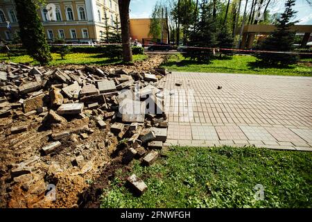 Ein Warnband verbietet den Durchgang. Absperrband um den gefährlichen Ort. Reparaturarbeiten an der Stelle des Asphaltausfalls nach der Katastrophe. Absperrband Stockfoto