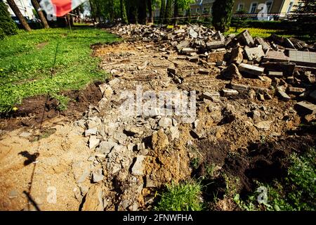 Ein Warnband verbietet den Durchgang. Absperrband um den gefährlichen Ort. Reparaturarbeiten an der Stelle des Asphaltausfalls nach der Katastrophe. Absperrband Stockfoto