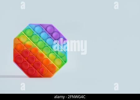 Neue beliebte Silikon bunte Antistress Pop es Spielzeug auf grauem Hintergrund. Platz für Text. Stockfoto