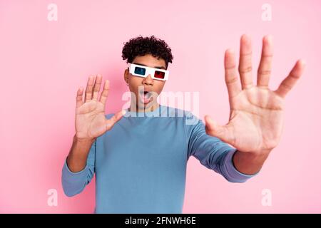 Fotoportrait eines jungen Mannes, der im Kino Filme ansieht 3d-Brillen essen Pop Mais lächelnd isoliert auf pastellrosa Farbiger Hintergrund Stockfoto