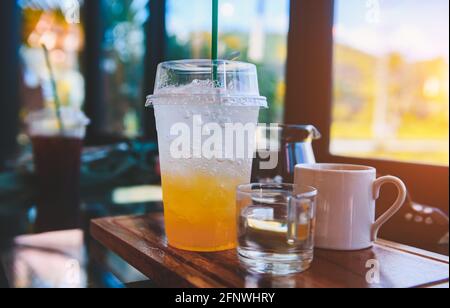 Orangensaft mit Limonadeneis und kalten Getränken im Café mit dezenter Beleuchtung im Innenbereich. Stockfoto