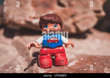 Beschädigte Spielzeugjunge Figur in rot und blau mit Auto auf der Brust anmelden Stockfoto