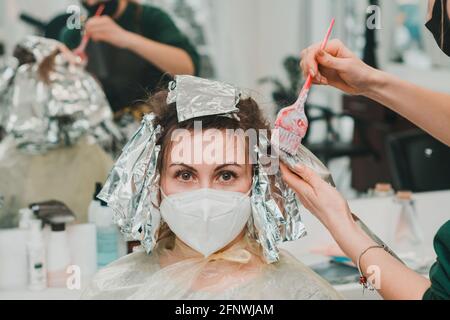 Frau färbt ihre Haare in einem Friseurladen, den Prozess des Färbens ihr Haar mit Folie. Neu Stockfoto
