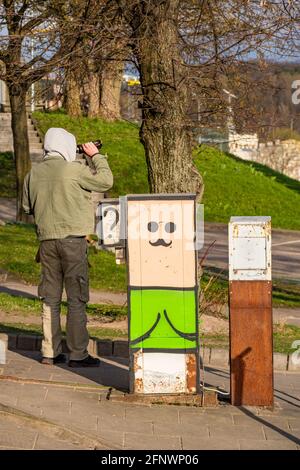 Betrunkener Mann trinkt aus einer Flasche auf der Straße in der Stadt, vertikal Stockfoto