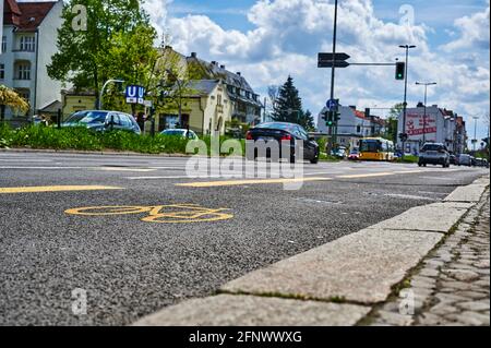 Berlin, Deutschland - 8. Mai 2021: Straßenszene mit temporär bemaltem Radweg in Berlin. Der Fokus liegt auf dem gelben Fahrradsymbol auf dem Asphalt. Stockfoto