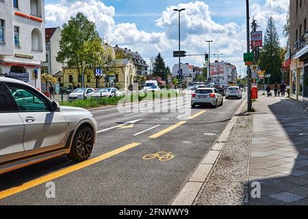 Berlin, Deutschland - 8. Mai 2021: Straßenszene mit temporär bemaltem Radweg in Berlin. Der Fokus liegt auf dem gelben Fahrradsymbol auf dem Asphalt. Stockfoto