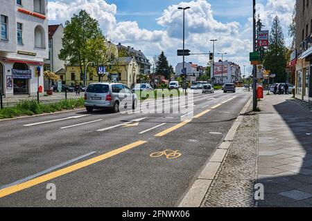 Berlin, Deutschland - 8. Mai 2021: Straßenszene mit temporär bemaltem Radweg in Berlin. Der Fokus liegt auf dem gelben Fahrradsymbol auf dem Asphalt. Stockfoto