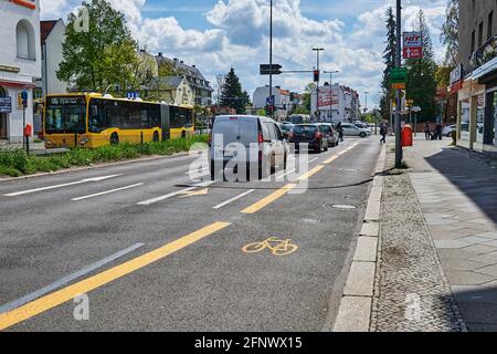 Berlin, Deutschland - 8. Mai 2021: Straßenszene mit temporär bemaltem Radweg in Berlin. Der Fokus liegt auf dem gelben Fahrradsymbol auf dem Asphalt. Stockfoto