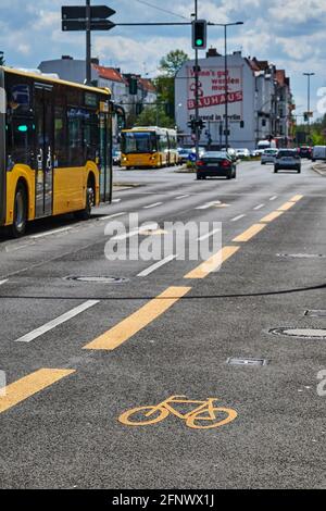 Berlin, Deutschland - 8. Mai 2021: Straßenszene mit temporär bemaltem Radweg in Berlin. Der Fokus liegt auf dem gelben Fahrradsymbol auf dem Asphalt. Stockfoto