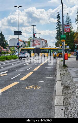 Berlin, Deutschland - 8. Mai 2021: Straßenszene mit temporär bemaltem Radweg in Berlin. Der Fokus liegt auf dem gelben Fahrradsymbol auf dem Asphalt. Stockfoto