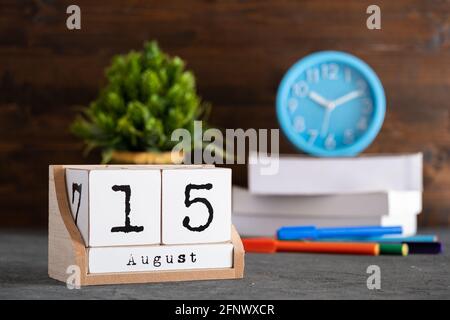 August. August 15 Holzwürfelkalender mit unscharfen Objekten auf dem Hintergrund. Stockfoto