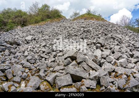 Oberlauf von Lathkill Dale im Derbyshire Peak District in Großbritannien mit Verderbhaufen des ehemaligen Ricklow-Steinbruchs Stockfoto