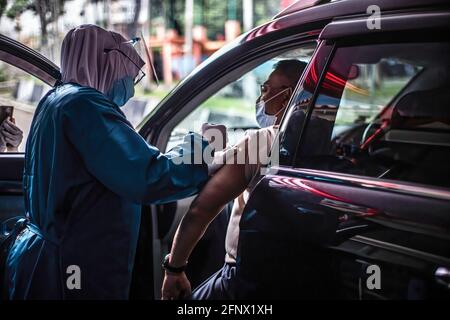 Bogor, West-Java, Indonesien. März 2021. Ein Arzt verabreicht einem Mann an einer Drive-Thru-Impfstelle eine Dosis Sinovac COVID-19-Impfstoff 19.die indonesische Regierung hat einen Drive-Thru-Impfdienst für 19 ältere Menschen in Bogor eröffnet.Quelle: Aditya Saputra/SOPA Images/ZUMA Wire/Alamy Live News Stockfoto