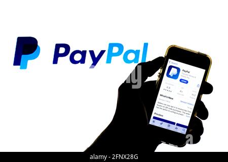 In dieser Abbildung wird eine PayPal-App im App Store auf einem Smartphone mit dem PayPal-Logo im Hintergrund angezeigt. Stockfoto