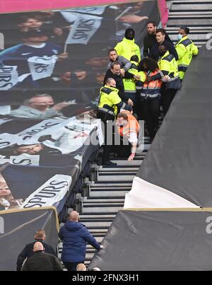 Stewards entfernen Fans, da sie sich weigern, das Stadion nach dem finalen Pfeifen während des Spiels der Premier League im Tottenham Hotspur Stadium, London, zu verlassen. Bilddatum: Mittwoch, 19. Mai 2021. Stockfoto