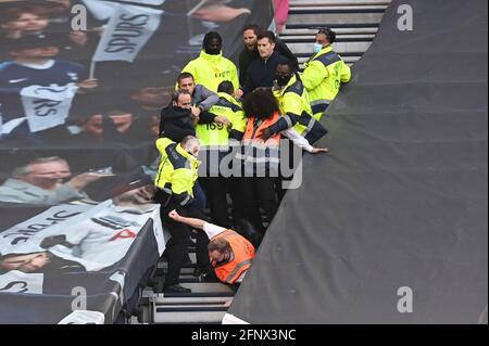 Stewards entfernen Fans, da sie sich weigern, das Stadion nach dem finalen Pfeifen während des Spiels der Premier League im Tottenham Hotspur Stadium, London, zu verlassen. Bilddatum: Mittwoch, 19. Mai 2021. Stockfoto