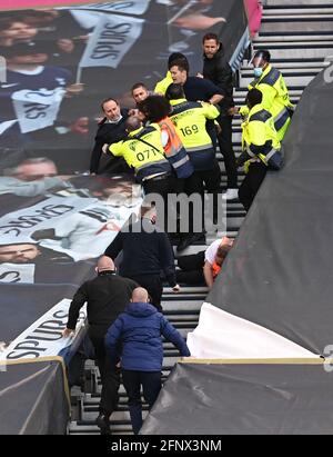 Stewards entfernen Fans, da sie sich weigern, das Stadion nach dem finalen Pfeifen während des Spiels der Premier League im Tottenham Hotspur Stadium, London, zu verlassen. Bilddatum: Mittwoch, 19. Mai 2021. Stockfoto