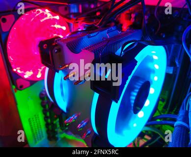 Moderne Computer Luftkühlung mit mehrfarbiger LED-Hintergrundbeleuchtung - Lüfter, Kühlern, Kabel, Boards, close-up. Stockfoto