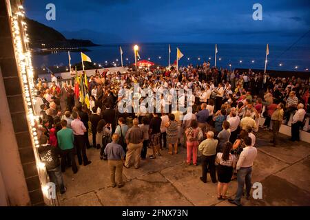 Menschen, die während nächtlicher Feierlichkeiten in Ribeira Quente der portugiesischen Marschkapelle lauschen. Sao Miguel, Azoren, Portugal. Stockfoto