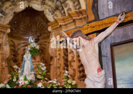 Bild des gekreuzigten Jesus Christus, mit Bild der Jungfrau Maria im Hintergrund. Kirche des Heiligen Geistes, Vila Franca do Campo, Azoren, Portugal Stockfoto