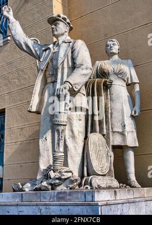 Die alte sowjetische Statue von Frau und Arbeiter. Skulpturen des Proletariats in der Nähe des Eingangs zum Bahnhof Mukatschewo, Ukraine. Stockfoto