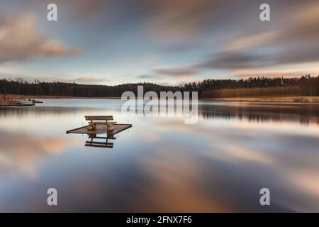 Kleiner holziger Fischerpier am See. Moody Farben des Sonnenuntergangs. Okuniewo, Woiwodschaft Pommern, Polen. Stockfoto
