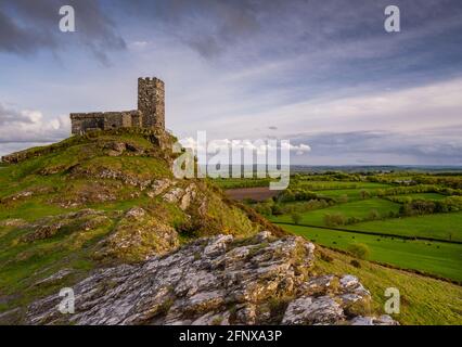 Brentor, Devon, Großbritannien. 19.. Mai 2021. Wetter in Großbritannien: Vor dem Sturm ruhig, da die Sonne am späten Nachmittag Brent Tor und die St. Michael de Rupe Kirche in goldenem Licht am frühen Abend vor den starken Winden und heftigen Regenfällen, die über Nacht aus dem Südwesten hereinrollen, baden wird. Quelle: DWR/Alamy Live News Stockfoto