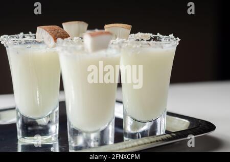 Kokosnusscocktail in Glas auf der Basis des Rums, dekoriert mit Kokosflocken, serviert auf einem silbernen Tablett, weiße Getränke Stockfoto