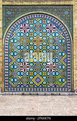 Schönes geometrisches Muster an der Wand des Golestan Palastes mit einer ovalen Nische, bemalte kleine Keramikfliesen Stockfoto