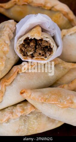 Traditionelle argentinische Empanadas, gefüllt mit salzigem Fleisch, Oliven, Zwiebeln, rotem Pfeffer, Ei, Gewürze, die alle in einer knusprig gebackenen Schicht verpackt sind, sind bereit zum Genießen! Stockfoto