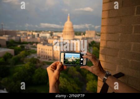 Austin, TX, USA. Mai 2021. Eine Frau nimmt ein Handy-Bild auf, während eine Bank von Mammatuswolken einem Regensturm über der Kuppel des Texas Capitol in Austin folgt, während ein Frühlingssystemdurchweht, das durch Zentral-Texas weht. Die Mammatokumulus zeichnen sich durch baumwollartige Schwellungen und dramatische Formationen aus. Quelle: Bob Daemmrich/ZUMA Wire/Alamy Live News Stockfoto