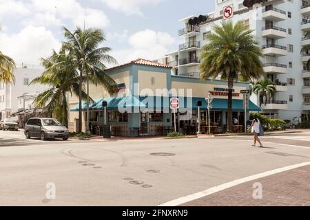 Eine Frau überquert die Straße vor dem kubanischen Restaurant Puerto Sagua in Miami Beach, Florida, USA Stockfoto