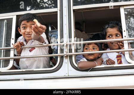 Mischevious Sri Lanka Schuljunge bietet Essen aus dem Busfenster, Anuradhapura, Sri Lanka Stockfoto