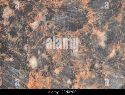 Grauer Granit mit orangen und weißen Adern, Nahaufnahme einer flachen Oberfläche aus Naturstein. Hintergrund, Muster, Textur. Stockfoto