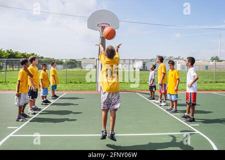 Miami Florida, Hadley Park Dade County Parks Sommercamp Programm, hispanischer Junge Jungen Kinder Basketball schießen Foul Schuss Ballkorb, Stockfoto