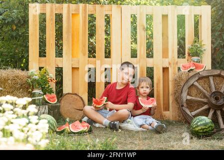 Lustige Kinder Jungen essen eine Wassermelone im Hinterhof gesund Snack Stockfoto