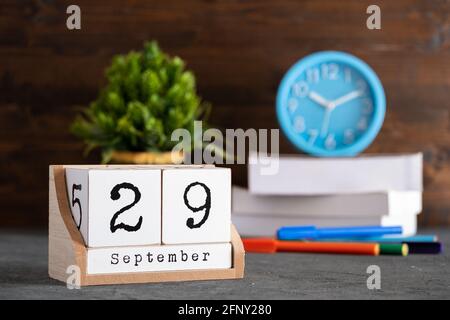 September. September 29 Holzwürfelkalender mit unscharfen Objekten auf dem Hintergrund. Stockfoto