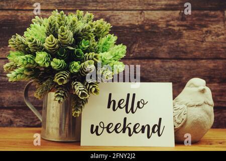 Hello Weekend Card mit blühender Blume auf hölzernem Hintergrund Stockfoto