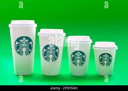Calgary, Alberta, Kanada. 19.Mai 2021. Starbucks Kaffeetassen in verschiedenen Größen auf grünem Hintergrund. Stockfoto