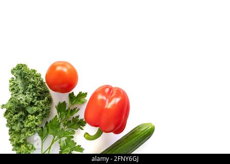 Gemüse isoliert auf weißem Hintergrund. Tomaten, Gurken, Grünkohl, Petersilie und Paprika bereit für den Salat. Gesunde Ernährung, Diät und vegetarische Konce Stockfoto