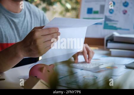 Ein Mann verwaltet, berechnet die Schulden und hält Kosten Rechnung. Stockfoto