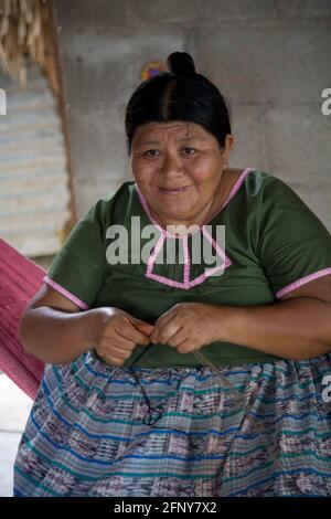 Maria Ack webt Körbe in ihrem Haus in der Maya-Gemeinde San Miguel, Toledo, Belize Stockfoto